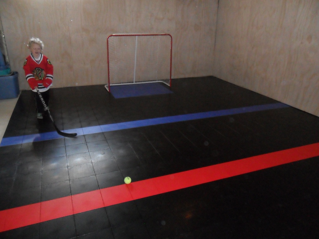 Basement hockey rink with a Sport Court floor.